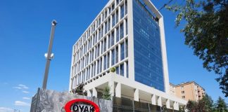 Türkiye’nin en büyük kurumsal yapılarından biri olarak gösterilen OYAK Holding, sanayi, çimento, otomotiv, enerji, madencilik, finans ve lojistik gibi birçok farklı sektörde faaliyet gösteren güçlü organizasyon yapısıyla dikkat çekiyor. 1961 yılında Ordu Yardımlaşma Kurumu olarak kurulan yapı, yıllar içinde gerçekleştirdiği yatırımlarla Türkiye ekonomisinin en önemli aktörlerinden biri haline geldi. Bugün hem yurt içinde hem de uluslararası pazarda faaliyet gösteren şirketleriyle büyümesini sürdüren OYAK Holding, çok sektörlü iş modeli sayesinde geniş bir ekonomik etki alanına sahip bulunuyor. Konulu bir haber görseli.