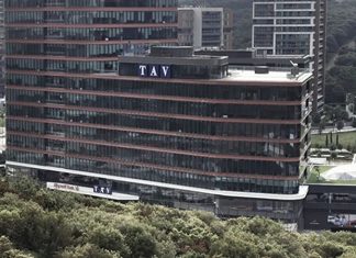 Türkiye merkezli küresel havalimanı işletmeciliği şirketleri arasında yer alan TAV Havalimanları Holding, havalimanı işletmeciliği, terminal hizmetleri, yer hizmetleri, duty free, yiyecek-içecek, bilişim ve güvenlik alanlarında faaliyet gösteren çok sektörlü yapısıyla dikkat çekiyor. 1997 yılında kurulan şirket, bugün Avrupa, Orta Doğu, Afrika ve Orta Asya’da faaliyet gösteren önemli havalimanı işletmecileri arasında yer alıyor. Özellikle uluslararası operasyon kapasitesi ve hizmet çeşitliliğiyle öne çıkan TAV Havalimanları Holding, Türkiye’nin küresel ölçekte marka değeri oluşturan şirketlerinden biri olarak değerlendiriliyor. Konulu bir haber görseli.